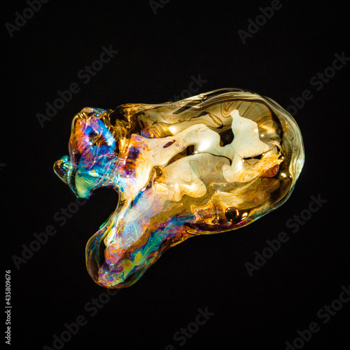 Amorphous and colorful isolated soap bubble with black background.
