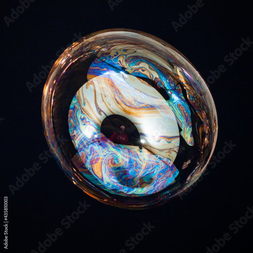 Amorphous and colorful isolated soap bubble with black background.