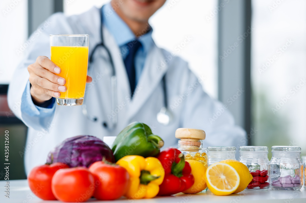 Asian nutritionist showing orange and juice Asian nutritionist showing orange and juice