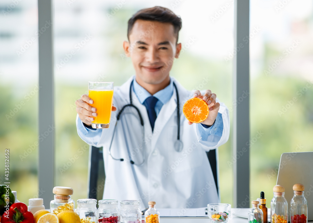 Asian nutritionist showing orange and juice Asian nutritionist showing orange and juice