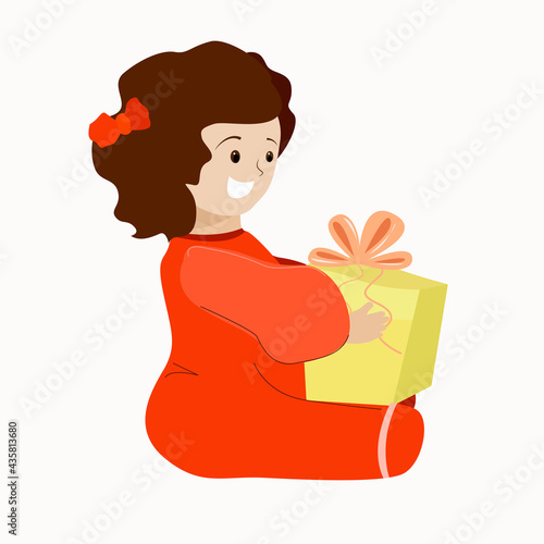 A little girl is sitting with a gift in her hands.
