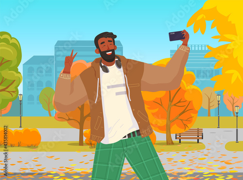 Young guy doing live streaming in autumn park. Video blogging concept. Social media network blogger. Man is broadcasting live with his smartphone. Person uses technology for video blog and broadcast