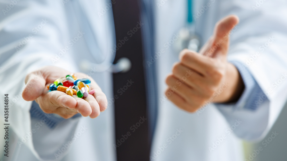 Unrecognizable medical practitioner showing pills