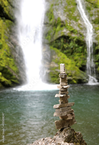 Stack of stones near a waterfall in the mountains called CAIRN or little man by mountaineers