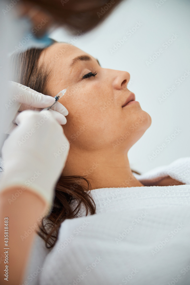 Female getting a beauty injection in a wellness center Female getting a beauty injection in a wellness center