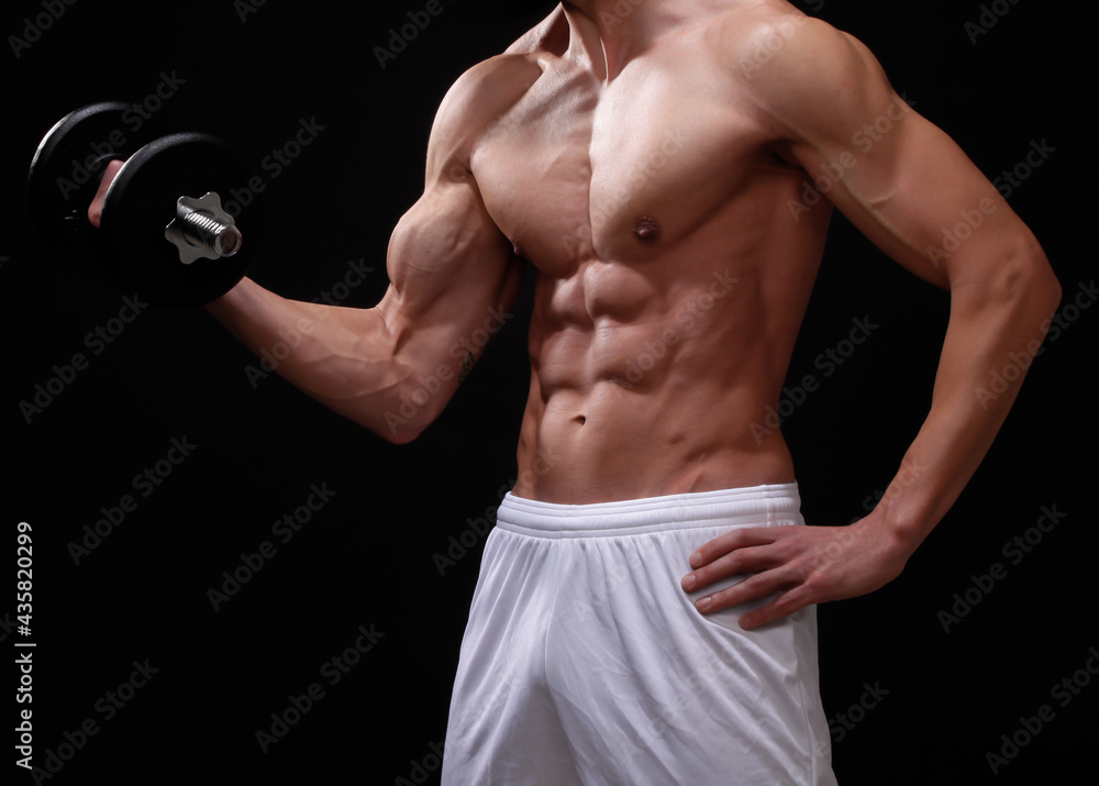 Muscular male lifting dumbbells - isolated fitness body of men