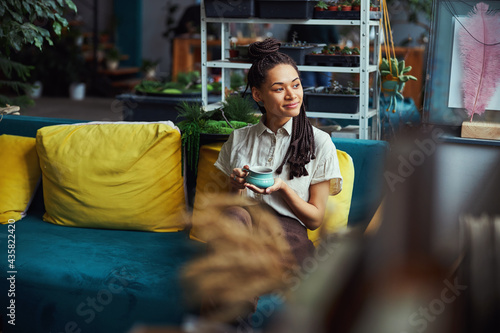 ovely young florist daydreaming during the coffee break photo