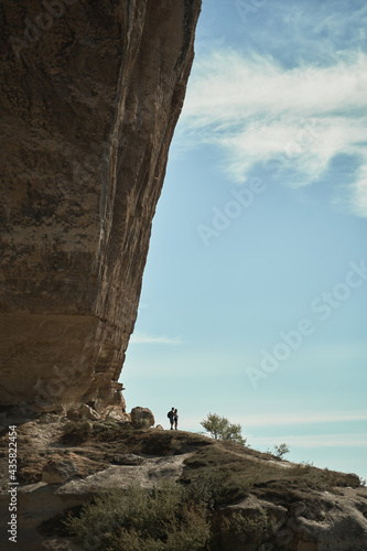 Couple stay on a rock, looking at the landscape and enjoying the view and fresh air.