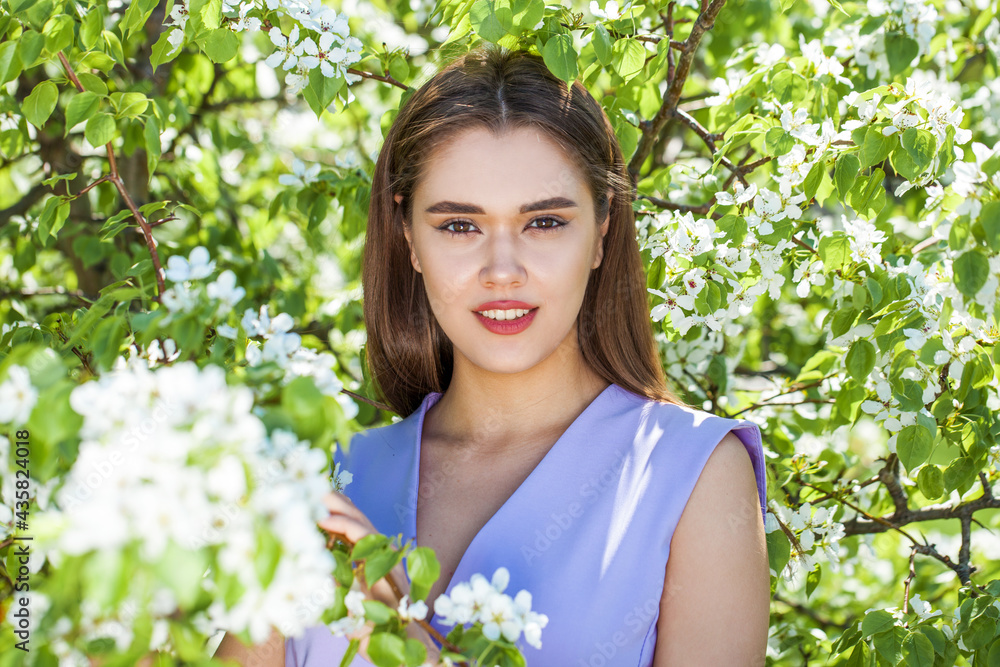 Young girl posing near blossom cherry tree with white flowers Young girl posing near blossom cherry tree with white flowers