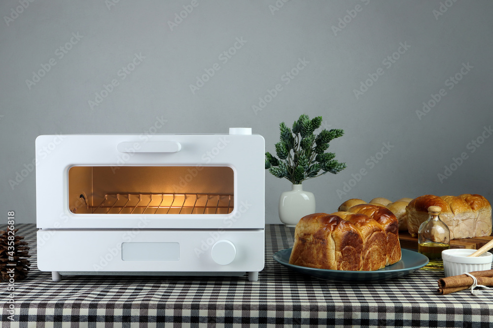 white modern design toaster oven , countertop or convection oven is on the  table with homemade toast breads on grey cement wall background in the  kitchen room during chritmas party Stock-foto