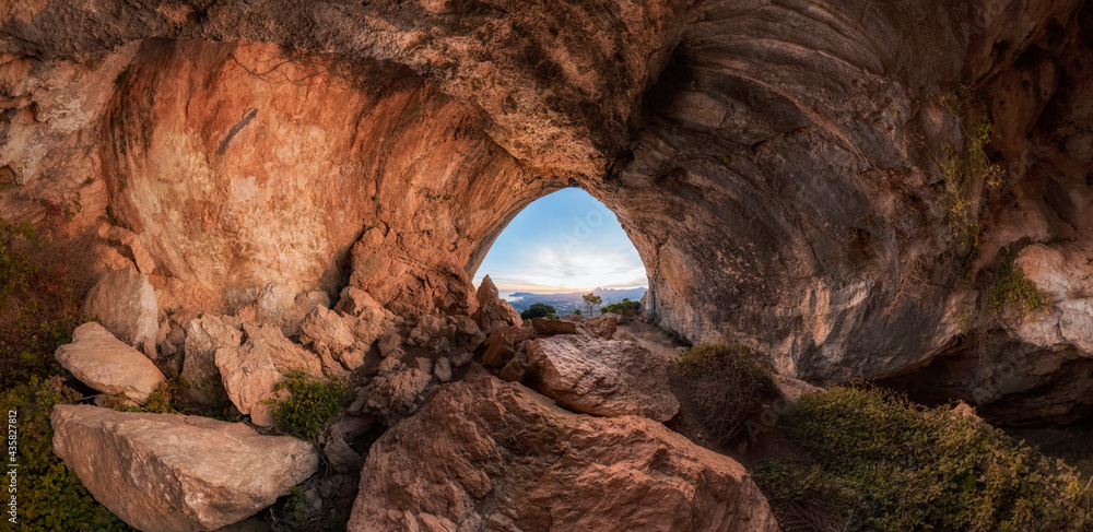 Watching the sunset inside a large rock cavern. Interior of a large ...