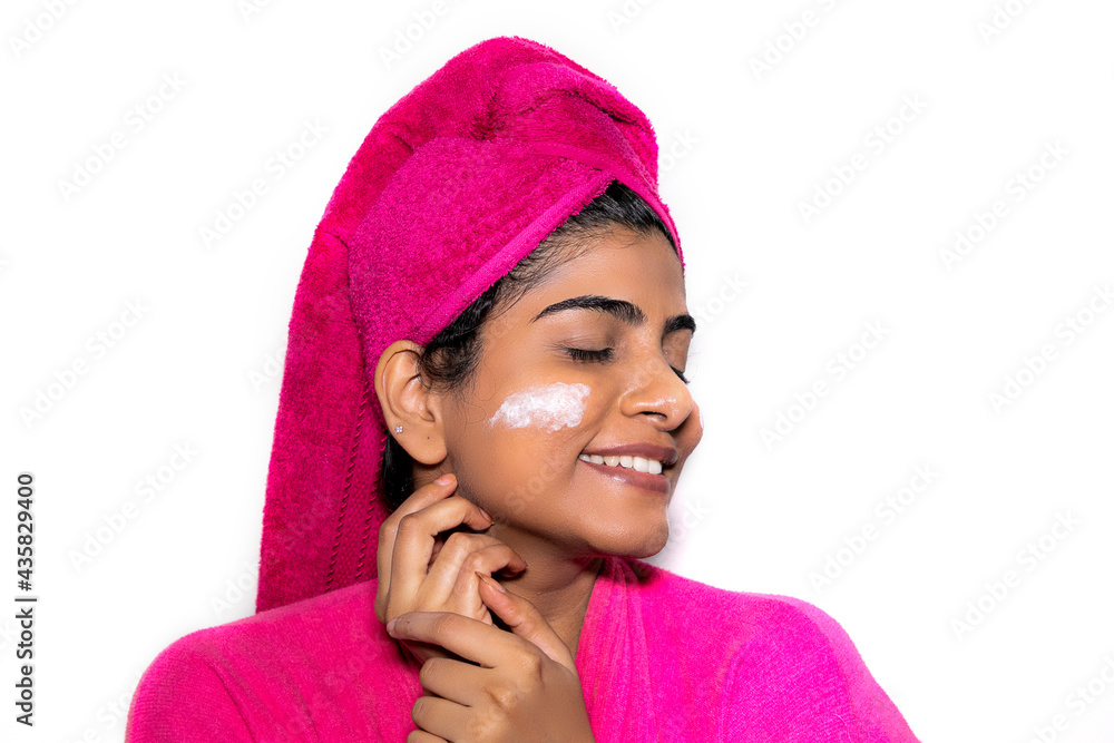 Beautiful Indian Lady in a pink bathrobe after bath giving beauty funny poses in front of the camera with body lotion and cucumber on her face Beautiful Indian Lady in a pink bathrobe after bath giving beauty funny poses in front of the camera with body lotion and cucumber on her face