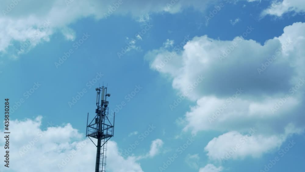 A Tower of GSM Mobile Operators and A Beautiful Time Lapse of White Puffy Flying Clouds in A Blue Azure Sky. A Tower of GSM Mobile Operators and A Beautiful Time Lapse of White Puffy Flying Clouds in A Blue Azure Sky.