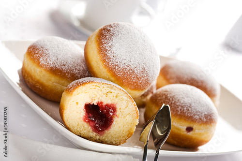 Slika na platnu Bismarck doughnuts filled with jam and decorated with confectioner's sugar on a