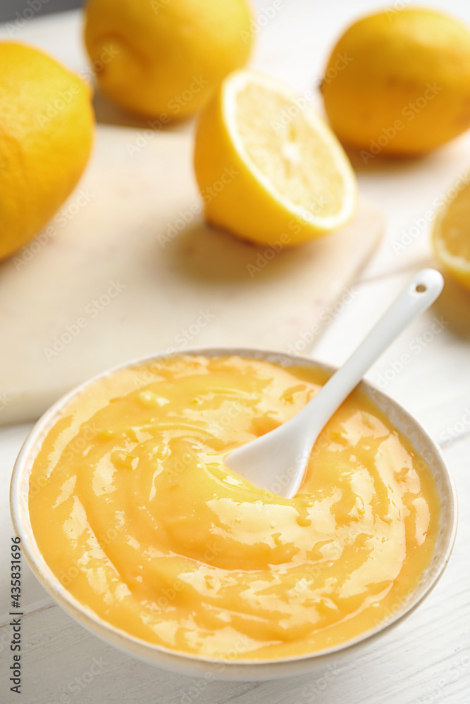 Delicious lemon curd in bowl on white wooden table. Space for text Delicious lemon curd in bowl on white wooden table. Space for text