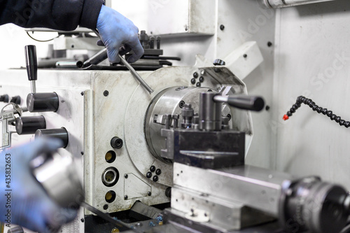 Close up view of worker operating a high precision turning operation on a multi axis lathe, CNC machine tool. High quality photo.