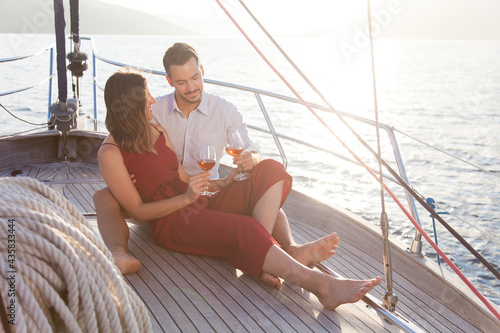 Couple in love drinking wine on yacht by sea. Happy travelers relaxing, traveling and enjoying summer vacation © Marina April