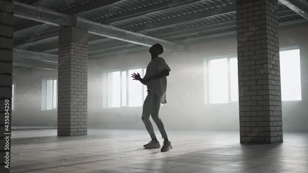A black man makes a football freestyle with a ball in an underground parking lot in the sunlight. Slow-motion shooting juggle the ball in the underground parking lot. A black man makes a football freestyle with a ball in an underground parking lot in the sunlight. Slow-motion shooting juggle the ball in the underground parking lot.