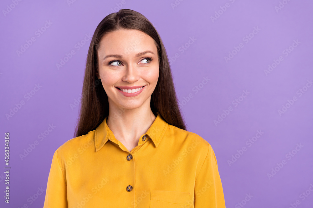 Photo portrait of woman smiling wearing yellow shirt looking blank space isolated on pastel violet color background Photo portrait of woman smiling wearing yellow shirt looking blank space isolated on pastel violet color background