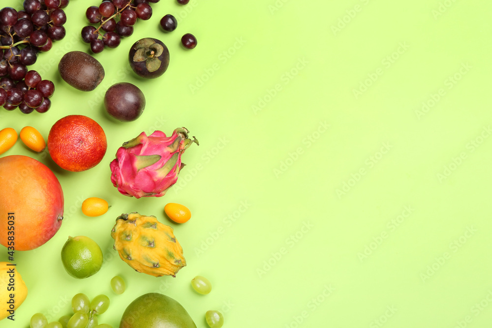Many different delicious exotic fruits on green background, flat lay. Space for text Many different delicious exotic fruits on green background, flat lay. Space for text