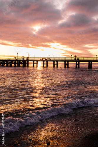 Beautiful sunset by the sea overlooking the city pier. Sunset over the sea surface.