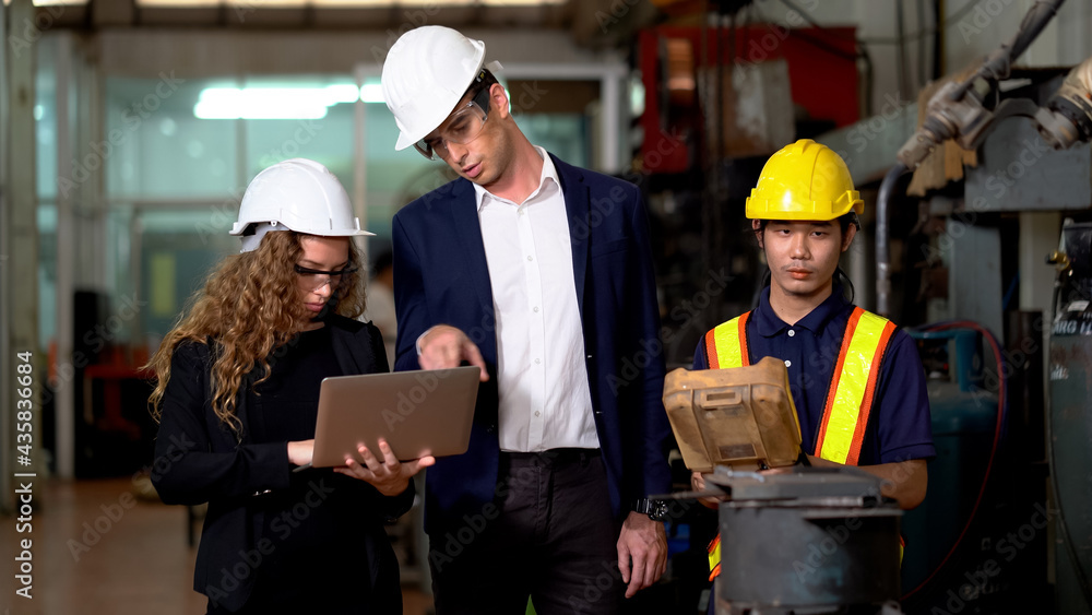 Manager engineer control Welding robot arms machine discuss with business woman using laptop computer checking monitoring system software of robotics automatic in factory industry. technology Manager engineer control Welding robot arms machine discuss with business woman using laptop computer checking monitoring system software of robotics automatic in factory industry. technology