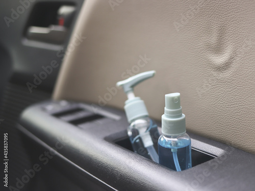alcohol spray bottle and alcohol sanitizer hand gel in car door armrest storage. Covid19 preventiong and new normal concept.