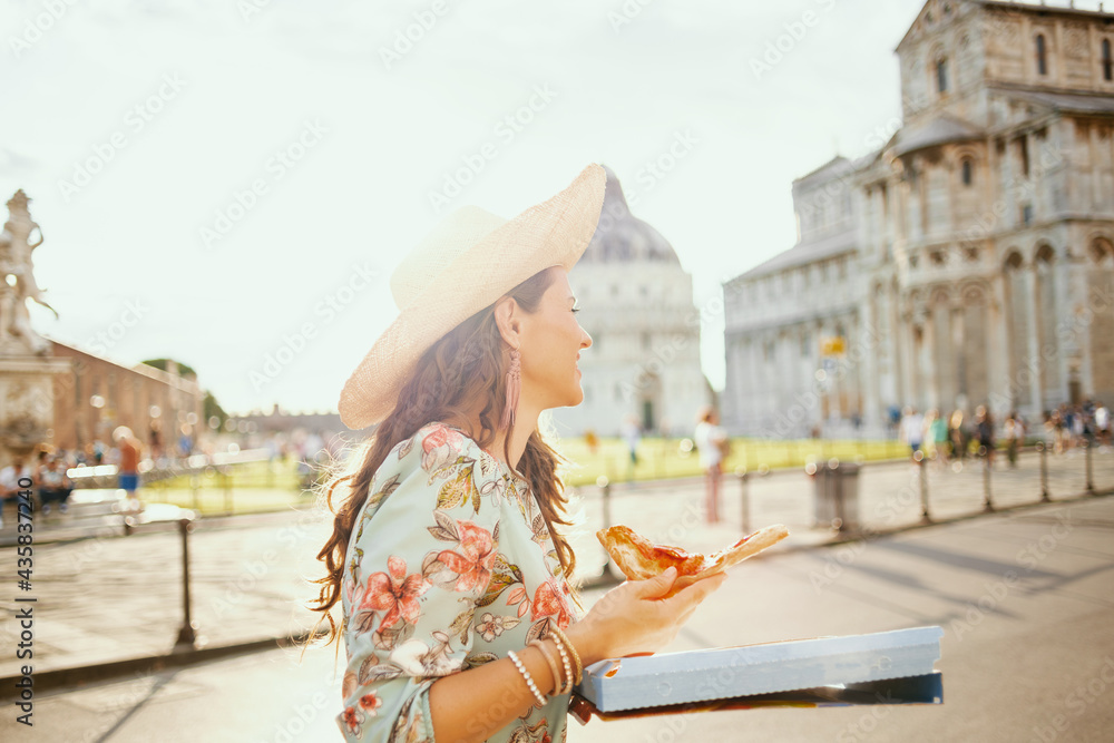 smiling elegant tourist woman in floral dress with pizza