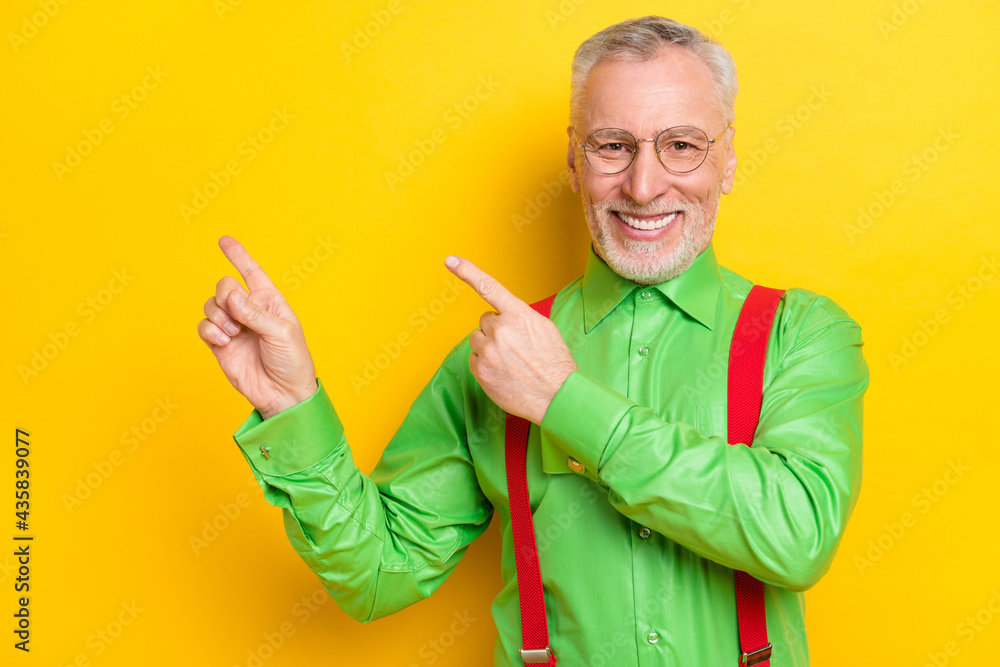 Photo of aged handsome man happy positive smile point fingers empty space ads advice select isolated over yellow color background Photo of aged handsome man happy positive smile point fingers empty space ads advice select isolated over yellow color background