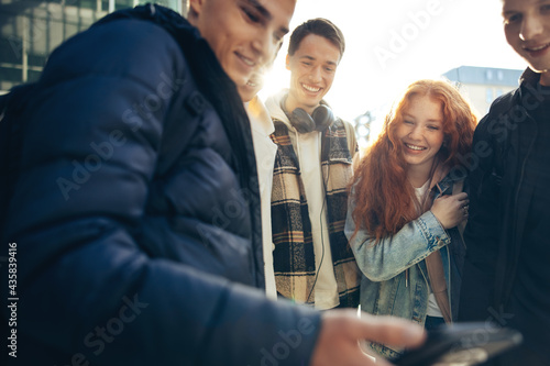 Boy showing phone to his friends