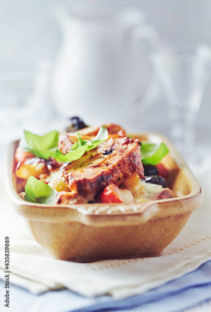 Pork tenderloin baked with Penne pasta, cherry tomatoes, black olives and cheese. Bright background. Close up Pork tenderloin baked with Penne pasta, cherry tomatoes, black olives and cheese. Bright background. Close up