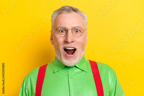 Photo of senior man happy positive smile amazed surprised omg wow news sale isolated over yellow color background