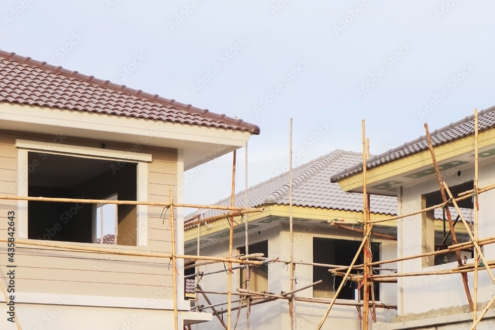 Obraz premium Image of home construction process with wooden bamboo scaffolding on construction site for property presentation and report background.