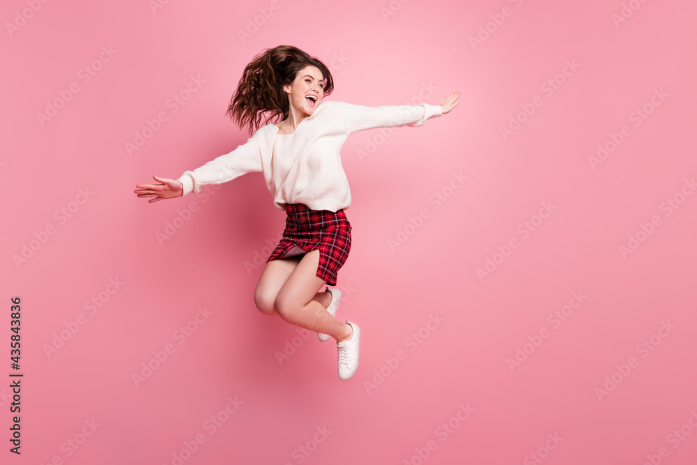 Full length profile side photo of young excited girl happy positive smile jump up hands wings fly isolated over pink color background