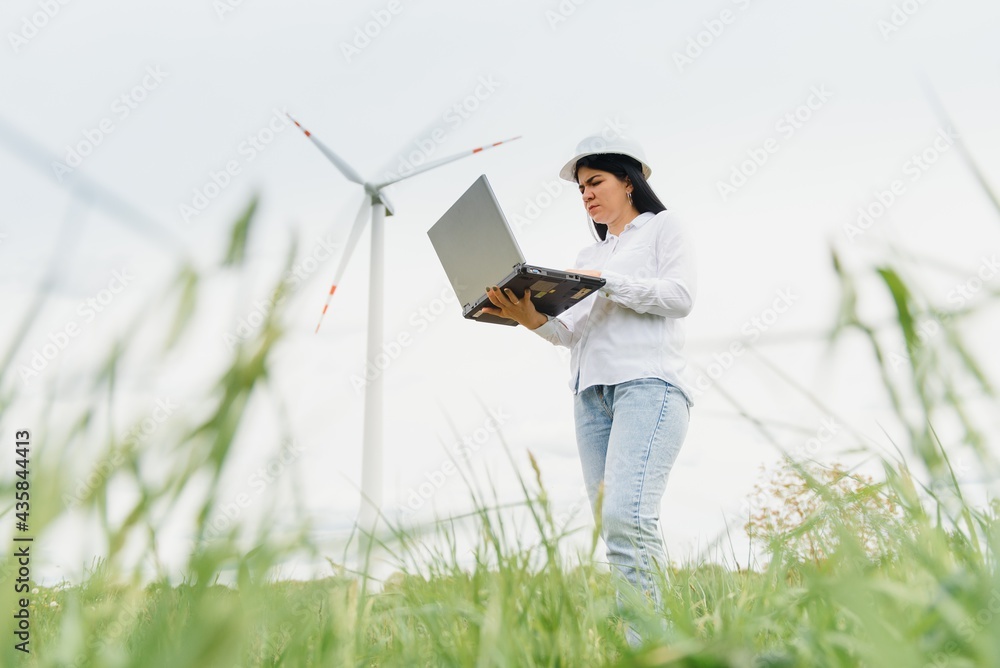 Environmental engineer with a laptop at wind farm Environmental engineer with a laptop at wind farm