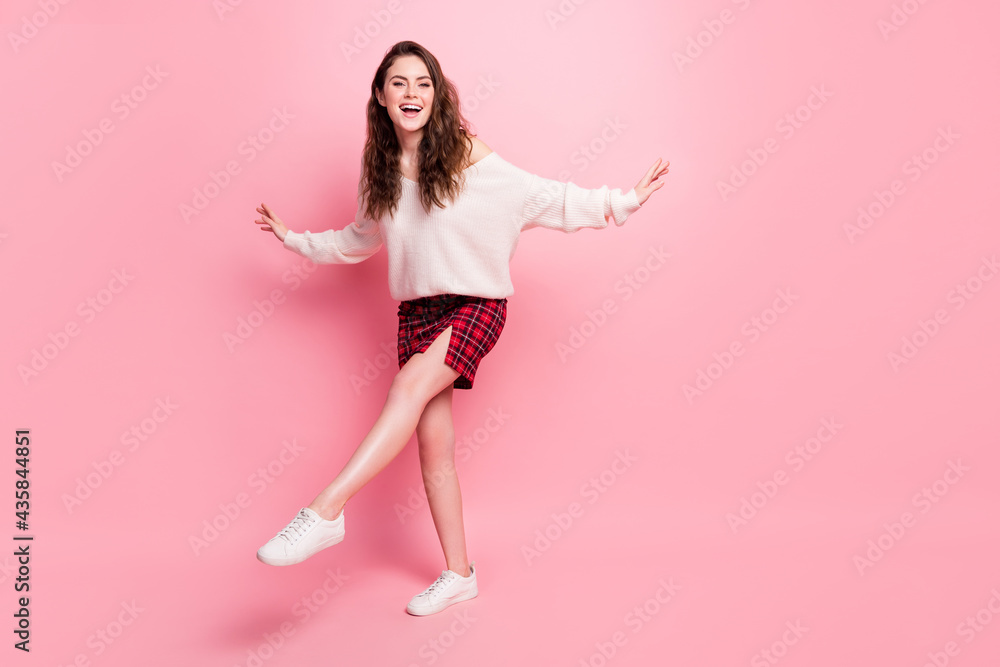 Full body portrait of excited crazy pretty lady arms flying raise foot beaming smile isolated on pink color background Full body portrait of excited crazy pretty lady arms flying raise foot beaming smile isolated on pink color background