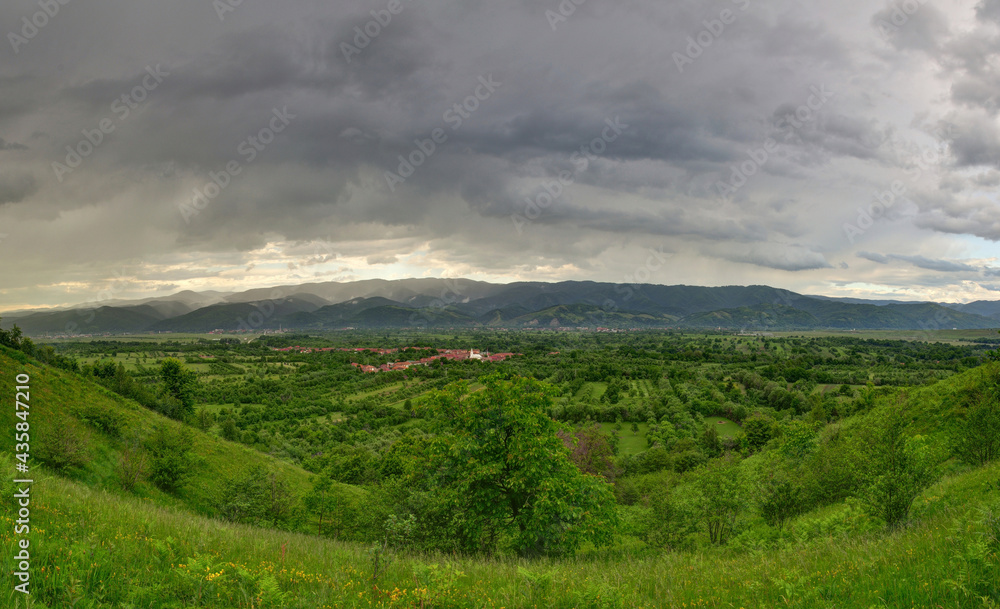 Storm scene with green hills and dark clouds Storm scene with green hills and dark clouds