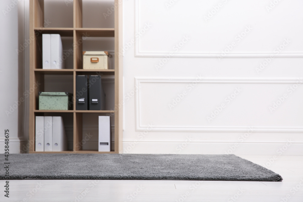 Room with soft grey carpet, shelving rack and white wall. Space for text Room with soft grey carpet, shelving rack and white wall. Space for text