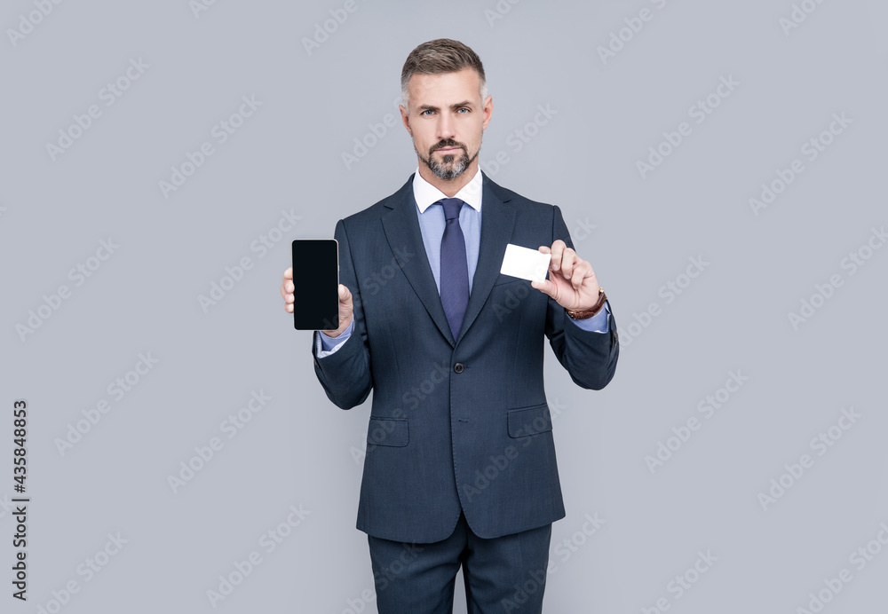 mature man advisor showing credit or debit card and smartphone copy space, online banking. mature man advisor showing credit or debit card and smartphone copy space, online banking.