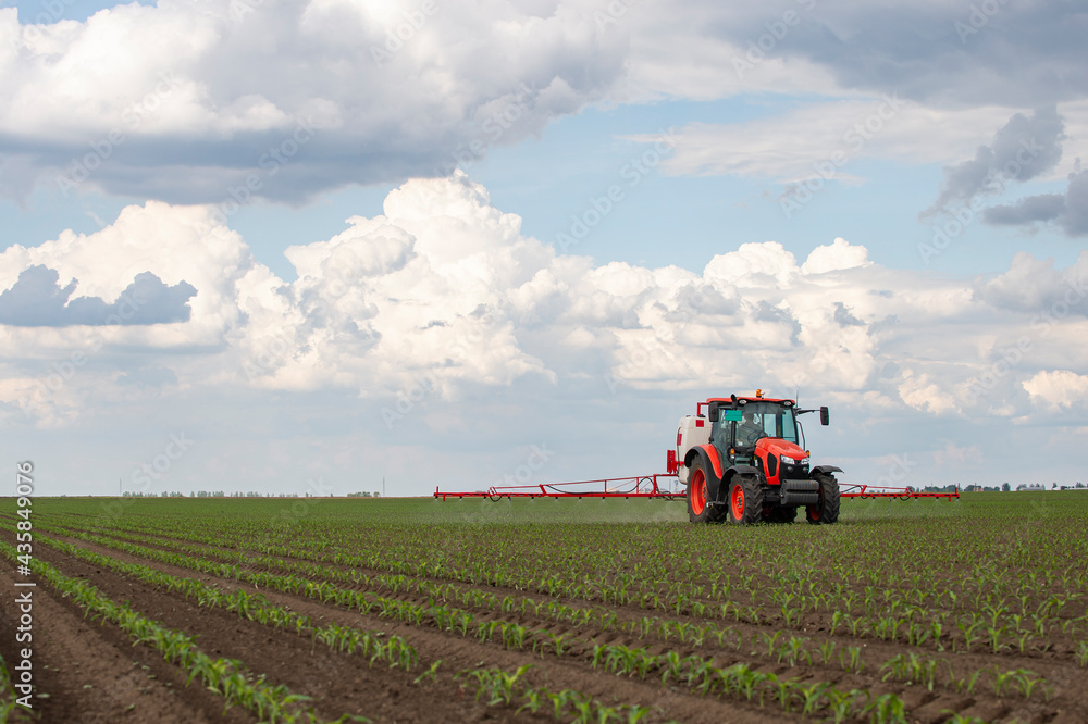 Tractor spraying pesticides at corn fields Tractor spraying pesticides at corn fields