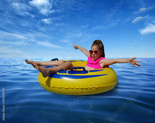  Little girl on inflatable ring in blue sea water