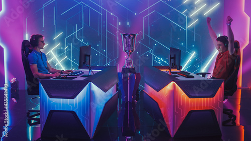 Two Professional Esport Gamers Compete in a Video Game on a Championship Arena, One Loses Round Disappointingly and Second Celebrates with Triumph. Duel Speedrun Streaming Cyber Gaming Tournament.