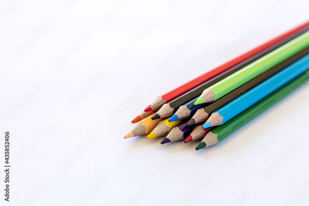 Close-up isolated, colorful pencils stacked on white paper. Close-up isolated, colorful pencils stacked on white paper.