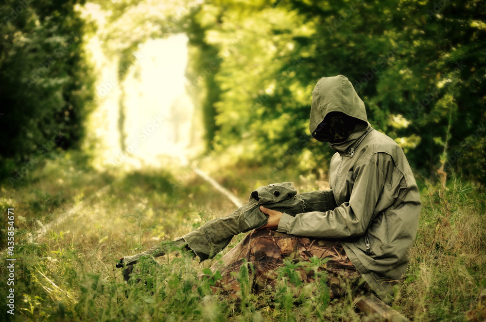 Naklejka premium Camouflage hunter aiming with his rifle