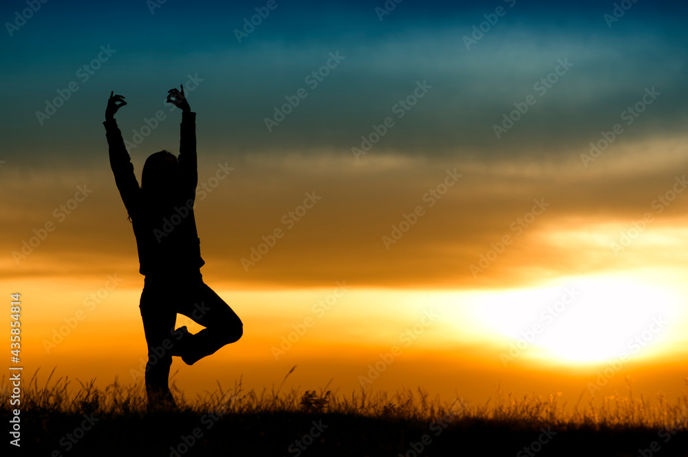 Silhouette young woman practicing yoga at sunset Silhouette young woman practicing yoga at sunset
