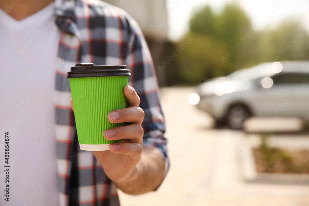 Man with takeaway coffee cup on city street, closeup. Space for text Man with takeaway coffee cup on city street, closeup. Space for text