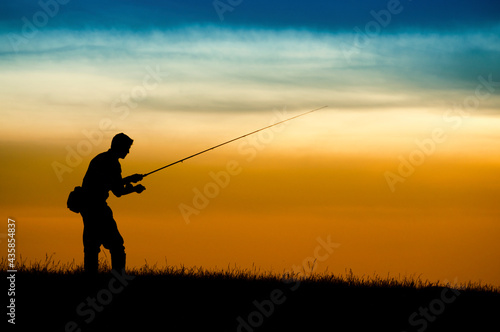 Silhouette of fisherman in sunset.