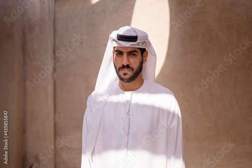 Portrait of arab man wearing dishdash kandura standing in historical disctrict photo
