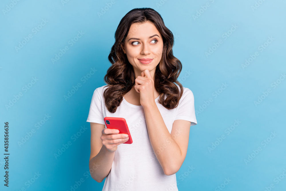 Photo of cute sweet young woman wear white t-shirt holding modern device smiling isolated blue color background