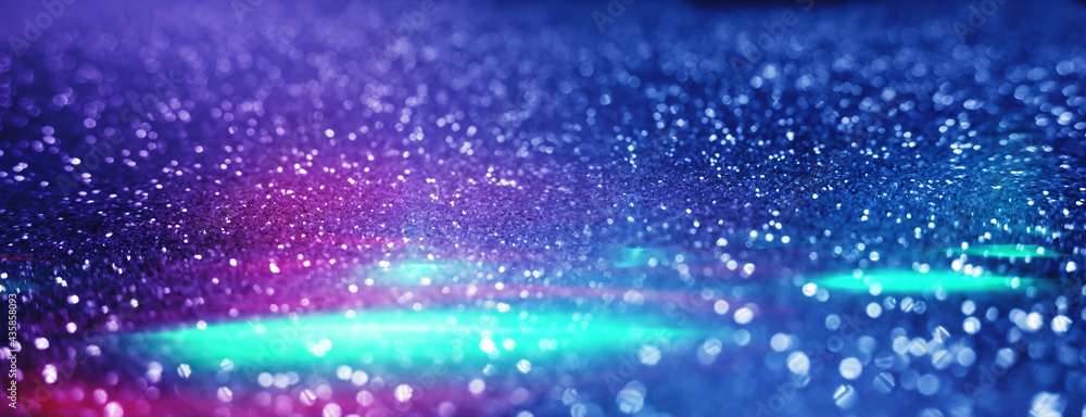 Blurred dark abstract background with glittering lights, bokeh. Ultraviolet glittering lights, sparks. Blurred dark abstract background with glittering lights, bokeh. Ultraviolet glittering lights, sparks.